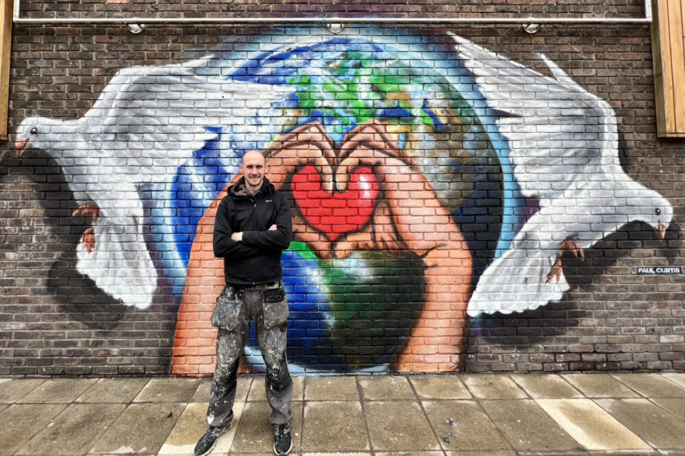 Paul Curtis with his Eurovision Mural: Peace & Love
