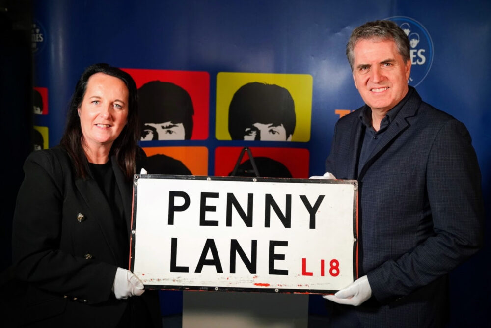 Manager of The Beatles Story Mary Chadwick, with Mayor of Liverpool City Region Steve Rotheram, holding the Penny Lane street sign. Credit: PA / The Beatles Story / LCR