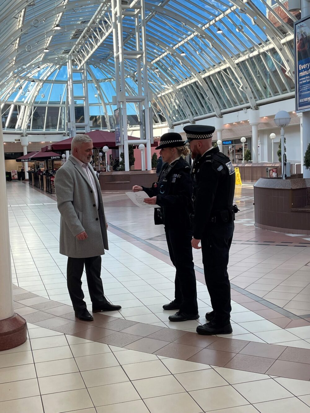 Neighbourhood Policing. Officers speaking to retail centre manager. Credit: Merseyside Police