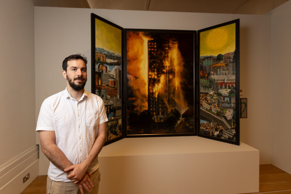 Nicholas Baldion with his painting Social Murder Grenfell in Three Parts. ©Robin Clewley