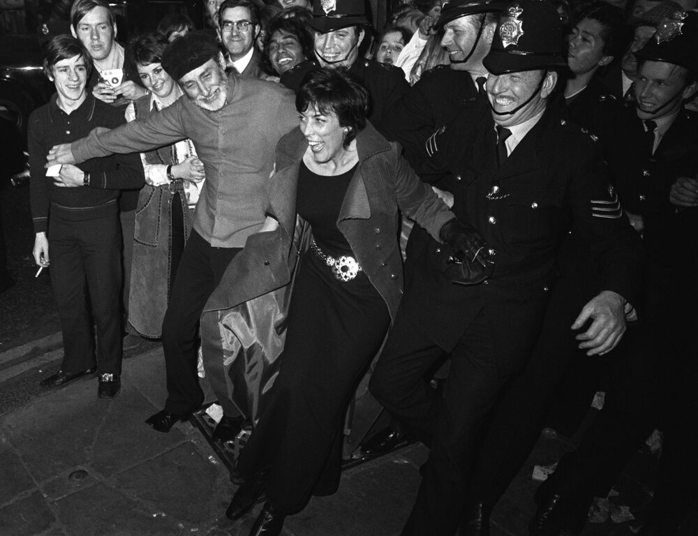 MAY 15th: On this day in 1970, The Beatles movie 'Let It Be' premieres in London. Comedian Spike Milligan and wife Patricia Ridgeway join hands with the police to keep surging crowds back at the premiere of 'Let It Be' at the london Palladium, Piccadilly Circus. Credit: PA