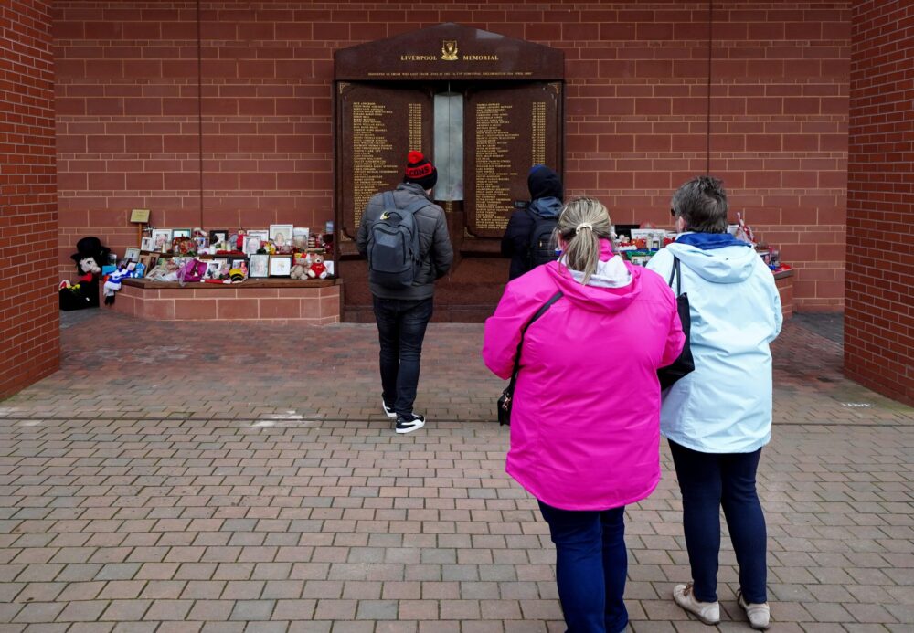 Passers-by take photographs of the updated Hillsborough monument in Liverpool in 2022. Credit: Peter Byrne/PA.