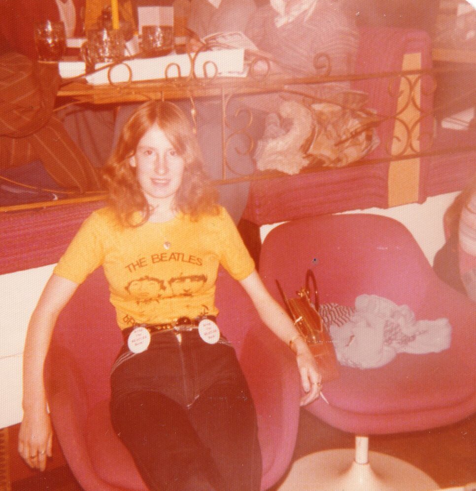 Ellen wearing a yellow The Beatles t-shirt at Mr Pickwicks nightclub, Liverpool, UK, 1977. "My friend and I were mad Beatle's fans, born a bit too late to be there in their heyday. We would attend conventions in Liverpool to mix with like-minded folk."