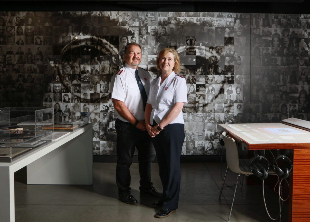 Major Allister Versfeld and Major Kathy Versfeld, in front of the John Lennon photomosaic. Image provided by Strawberry Field