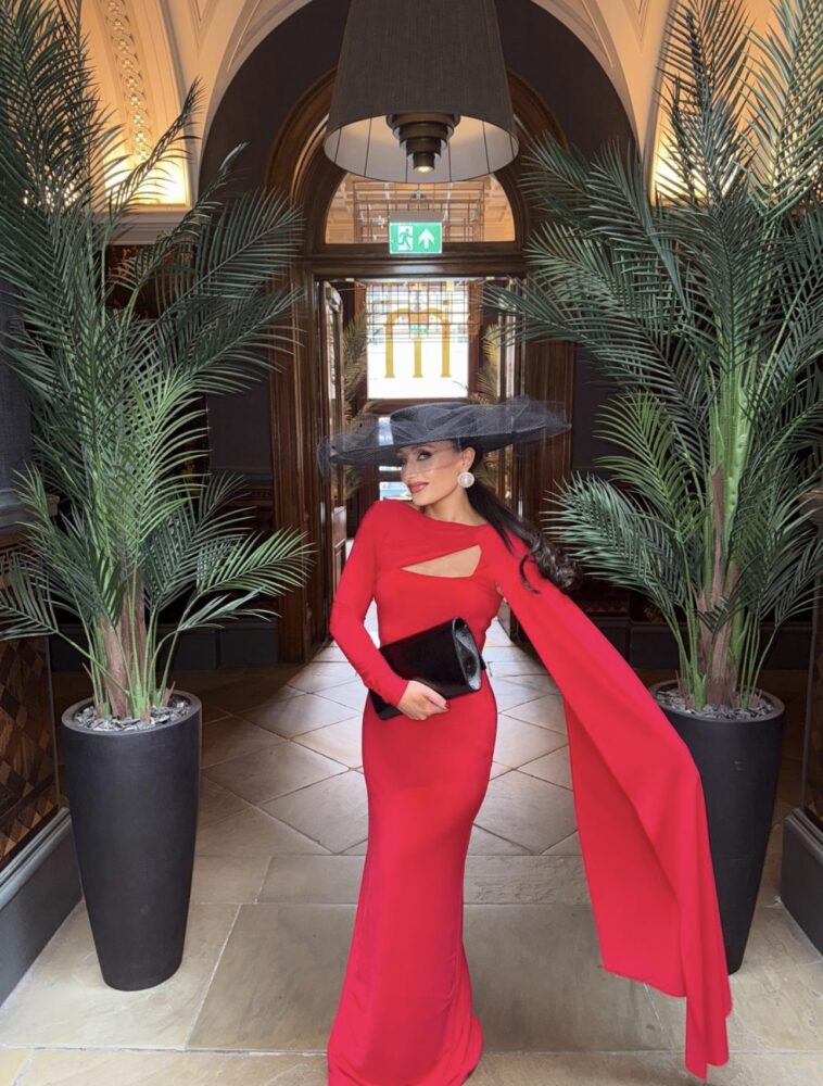 Linsey wears a cape dress by Club L London and hat by Tracey Miller