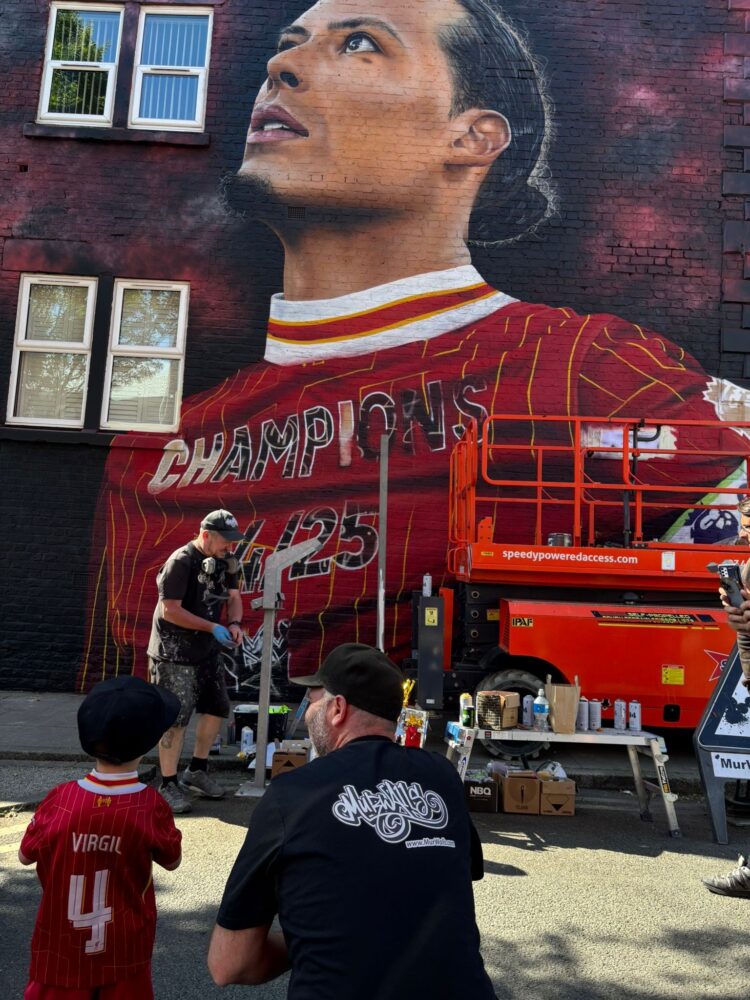 Isaac watches the finishes touches going on the Virgil mural